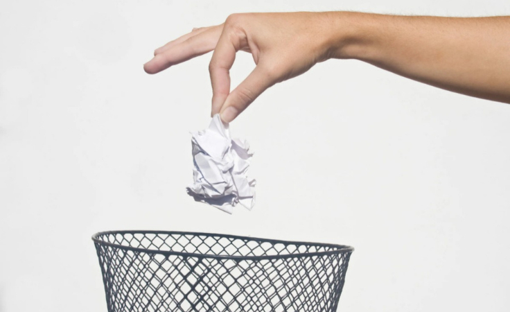 a biohacker drops paper in waste bin to get rid of negative energy
