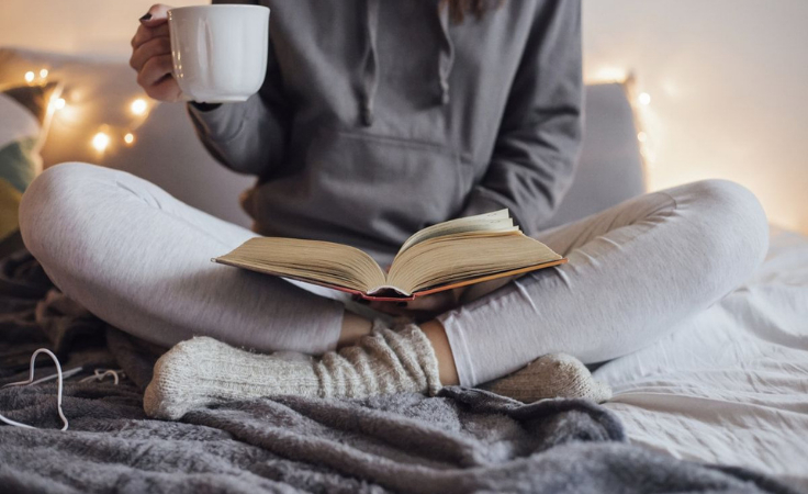 a biohacker enjoys book reading and coffee in a home free of negative energies
