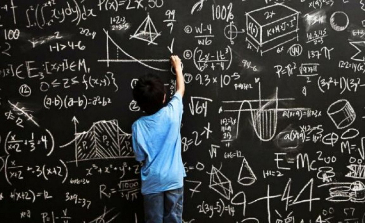 a young biohacker solves math problem on chalkboard as a brain balancing exercise