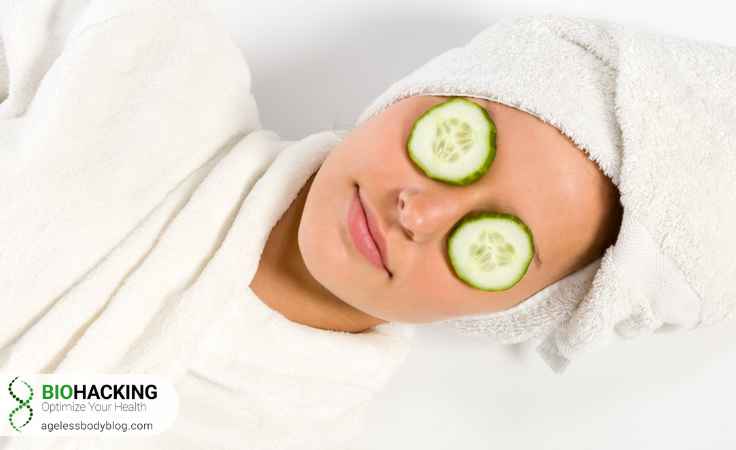 a biohacker wrapped in towel puts cucumber on eyes to tighten their eyelid